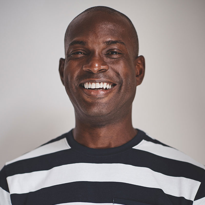 A man in striped shirt smiling for the camera.