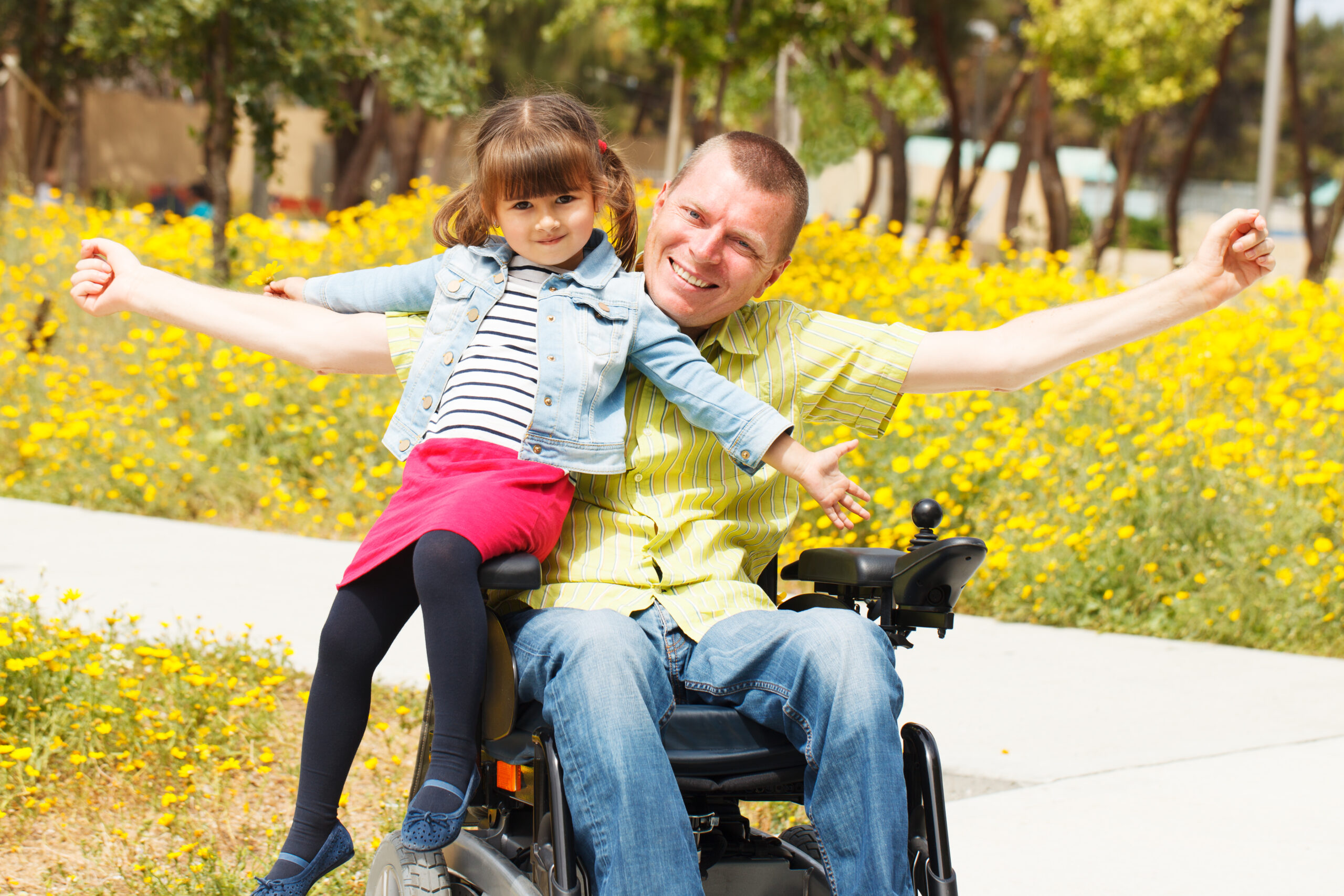 A man in a wheelchair holding his daughter.
