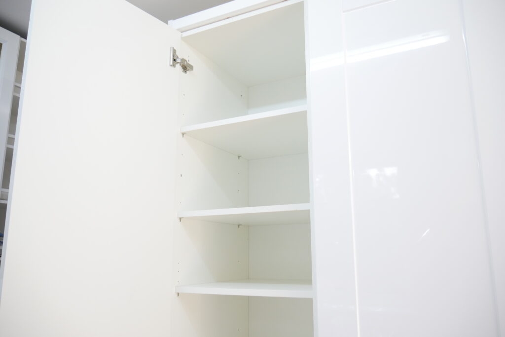 A white cupboard with shelves in it