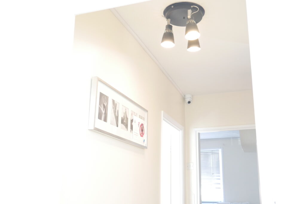 A hallway with two lights and a picture on the wall.