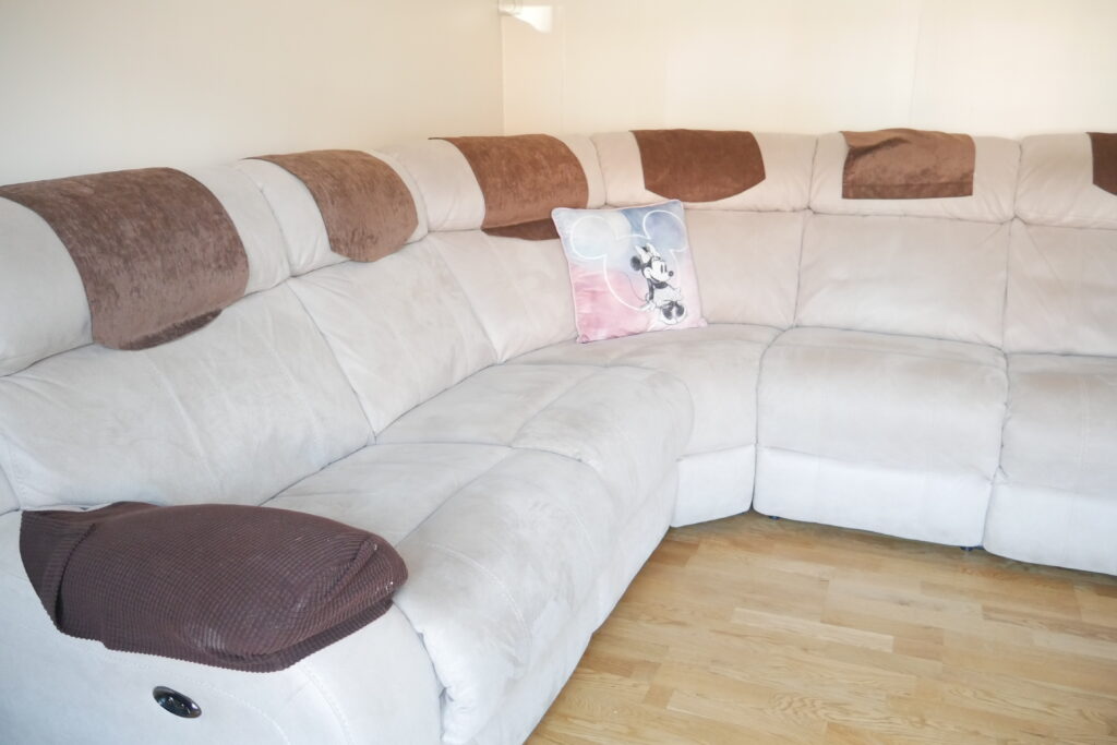 A white couch with brown and black pillows